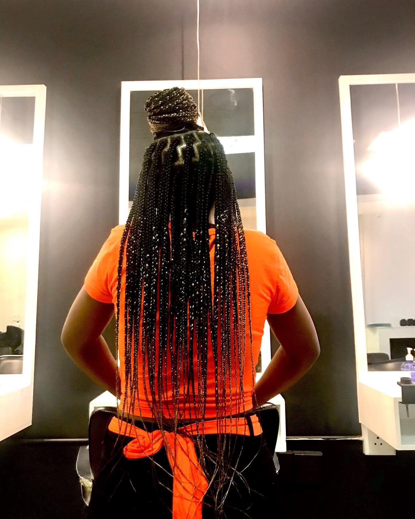 Knotless box braids styled in a half-up top knot